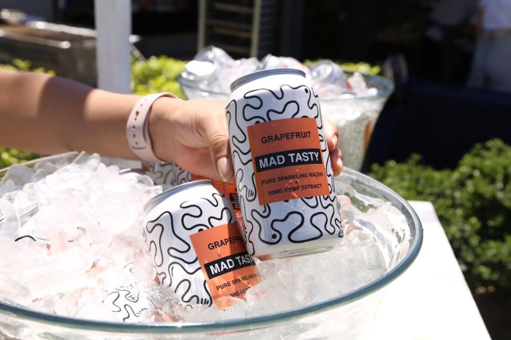 Mad Tasty cans held above bowl of ice.