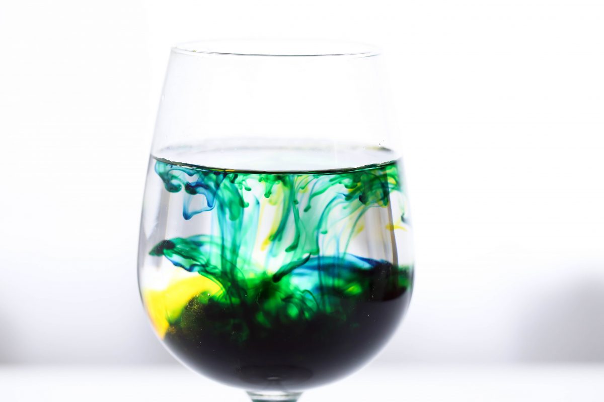 glass of liquid with colors emulsifying