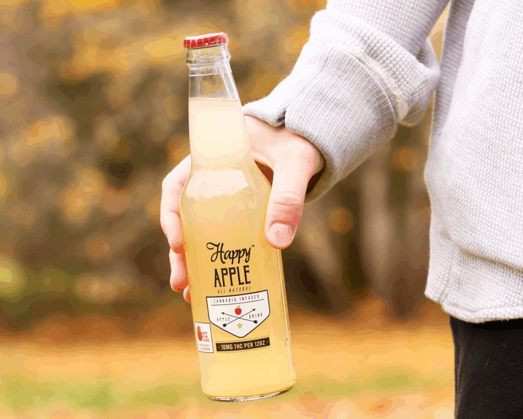 Person holding bottle of Happy Apple drink