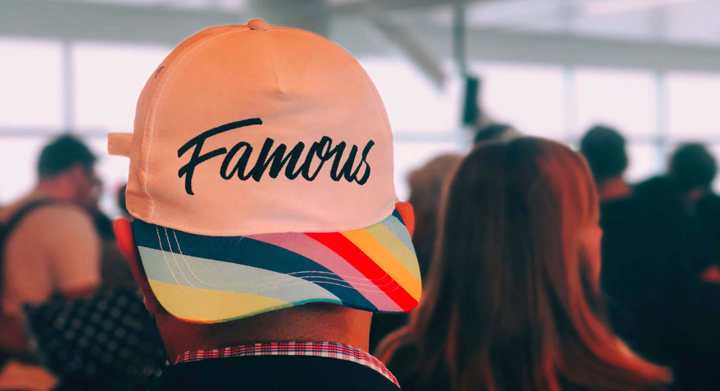 man wearing a hat labeled 'Famous'