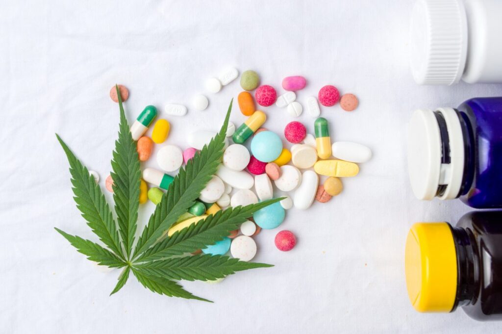 cannabis leaf and scattered pills