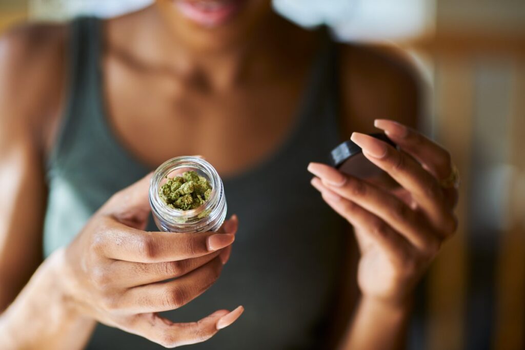 woman looking at a jar of cannabis